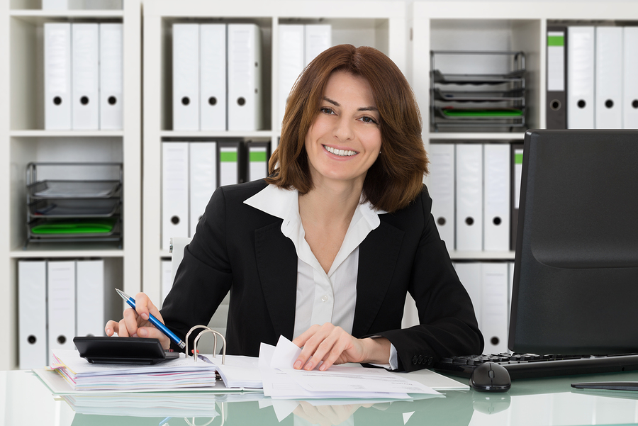 Portrait Of A Happy Accountant Woman Calculating Invoice